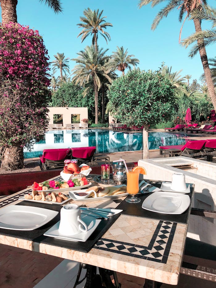 services-02 Enjoy a luxurious outdoor dining experience by the pool with lush greenery and delicious breakfast.